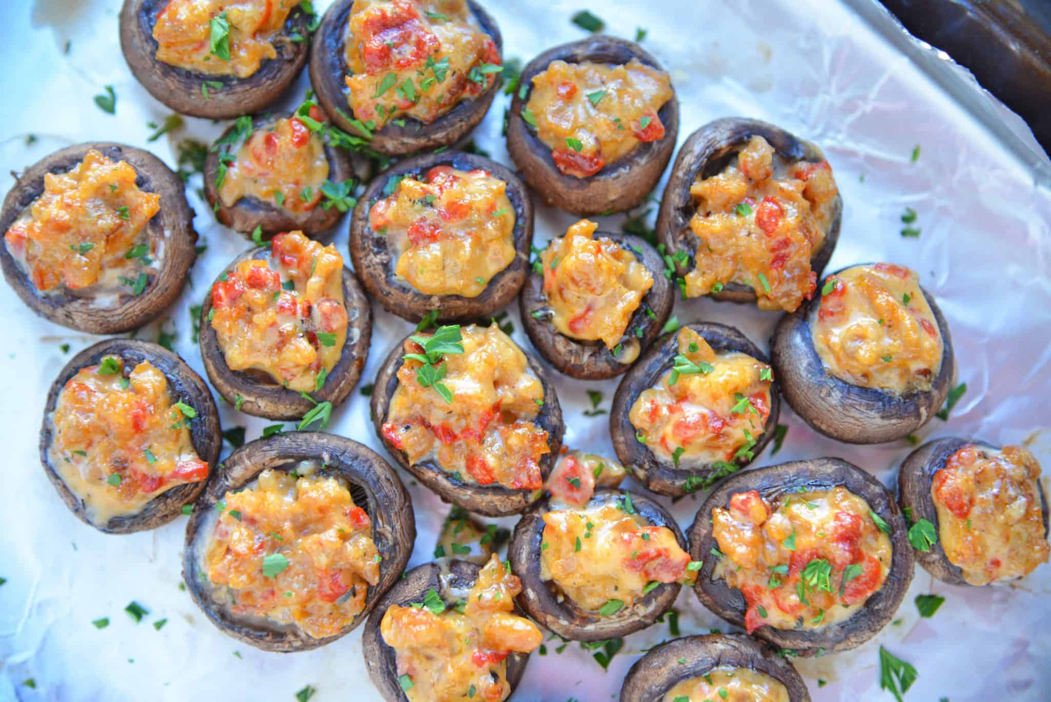 Alfredo sausage stuffed mushrooms on a baking sheet. 