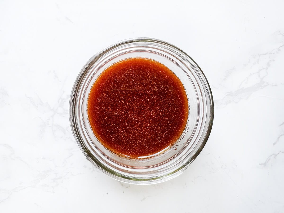 Top view of a small jar filled with a spicy sauce mixture.