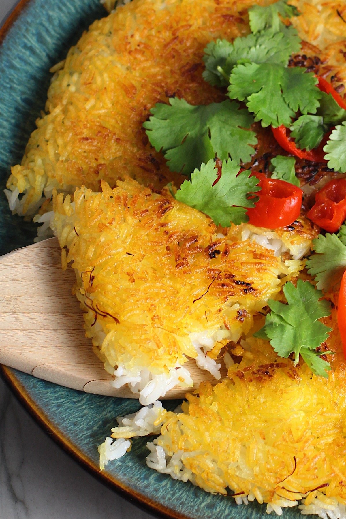 Saffron butter crispy rice garnished with cilatnro and slices of sweet red peppers. 
