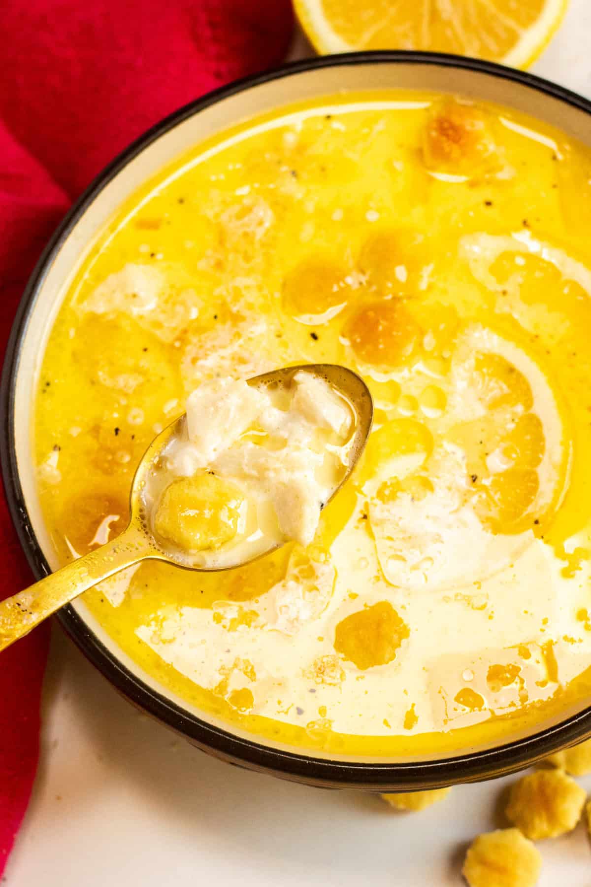 Top view of a bowl of creamy crab soup with a spoon over top.