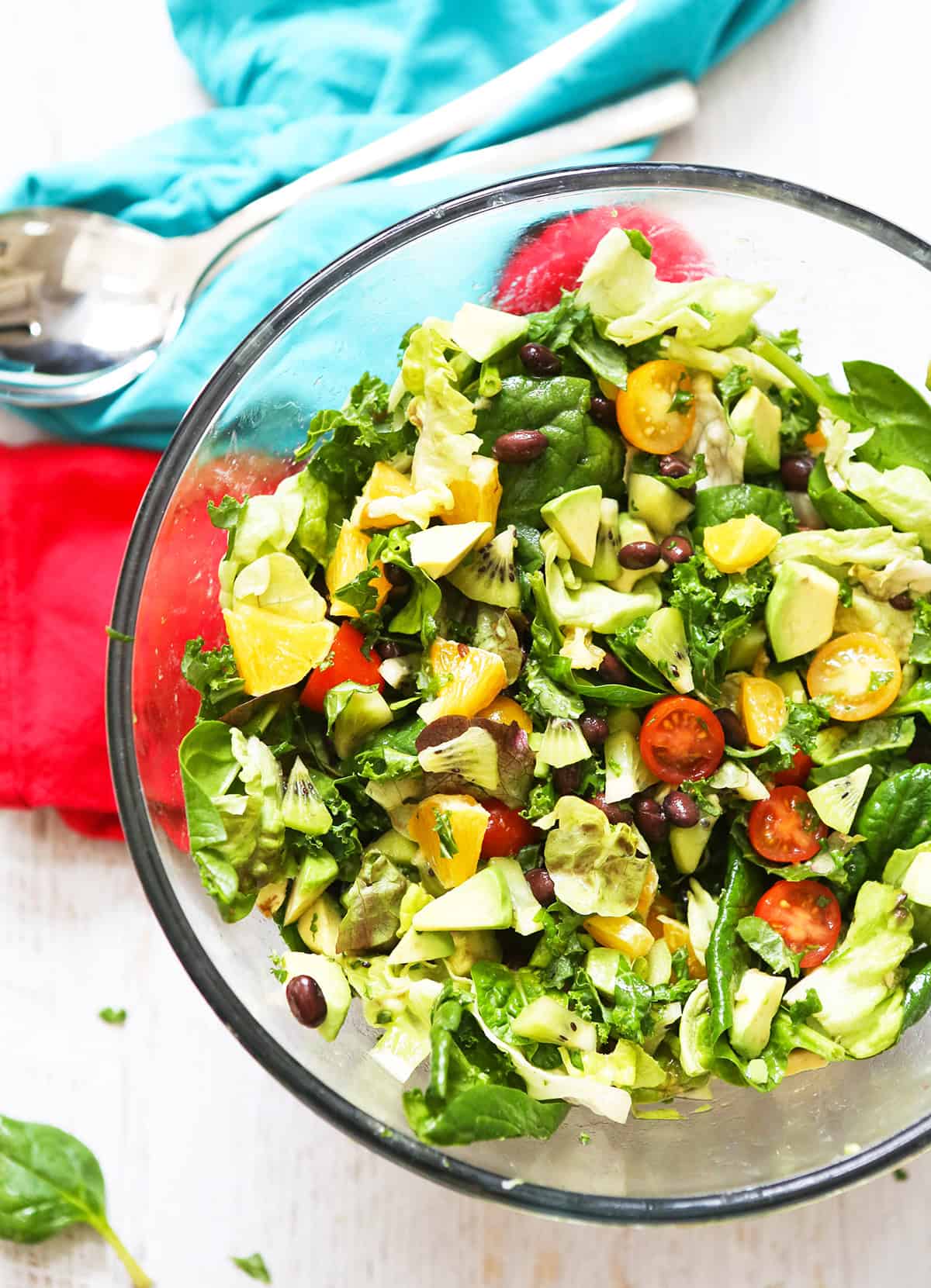 Top view of a serving bowl filled with kale salad and fruits and veggies mixed in.