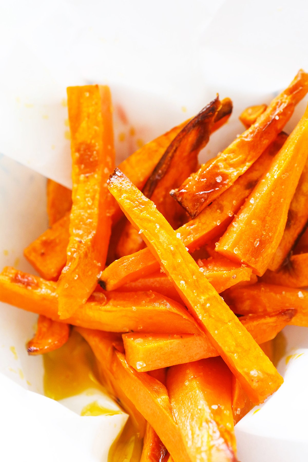 Sweet potato fries in parchment paper, sprinkled with salt.