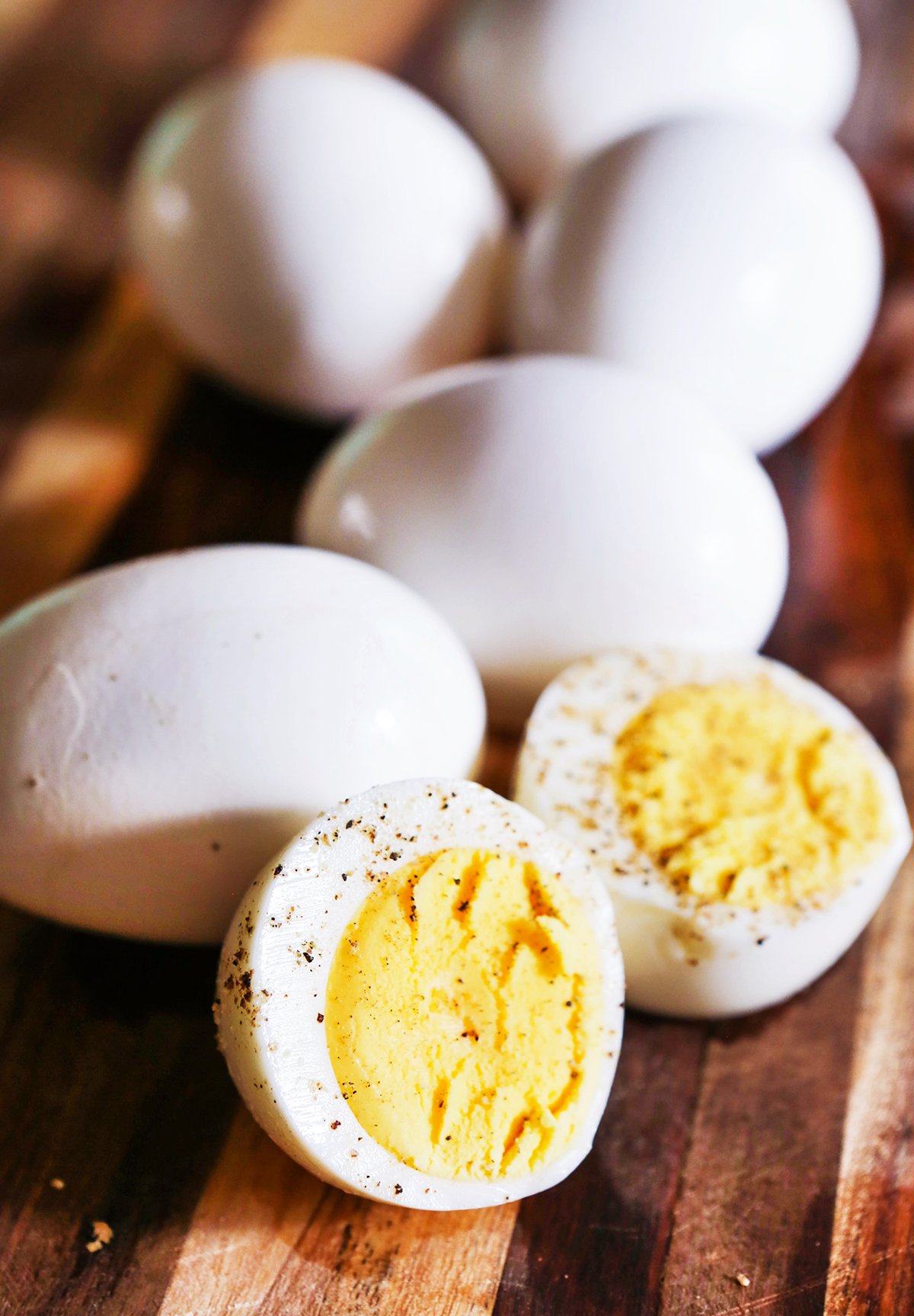 Hard boiled eggs with one peeled and cut in half, sprinkled with pepper. 