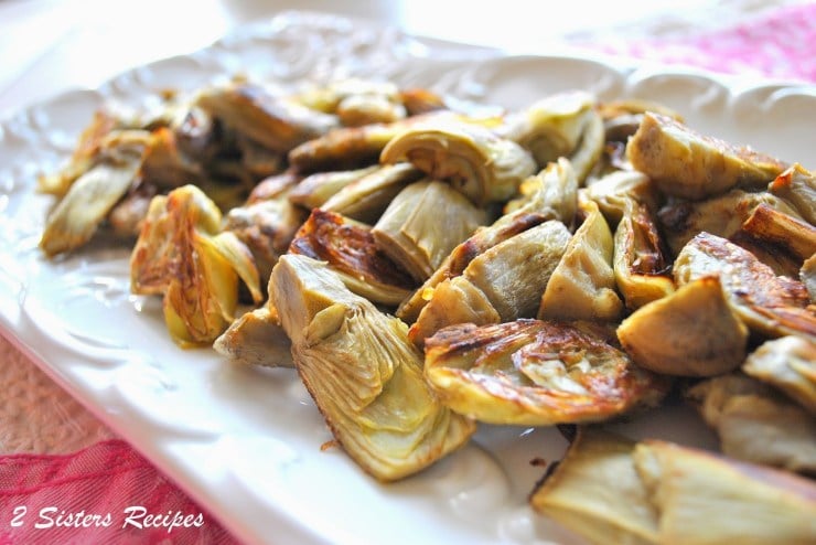 roasted artichoke hearts with lemon garlic aioli on a serving plate. 