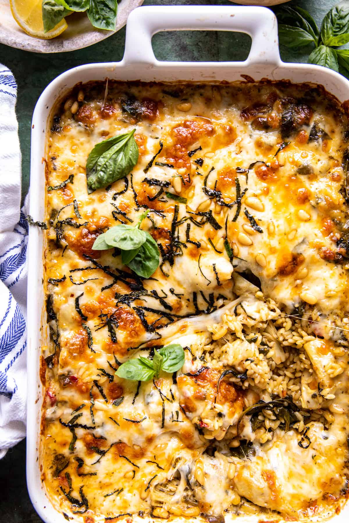 Baking dish of spinach and artichoke with orzo bake. 