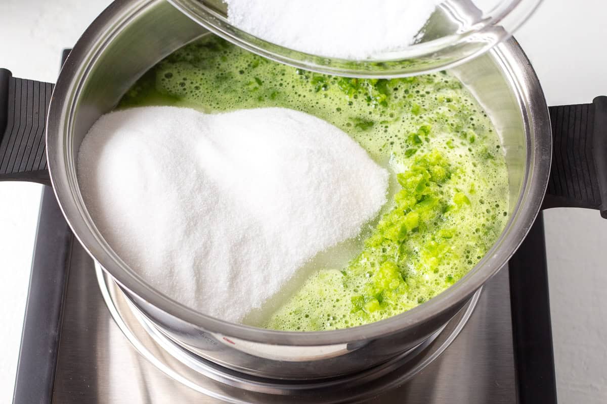 Green pepper jelly ingredients in a pot on stove.