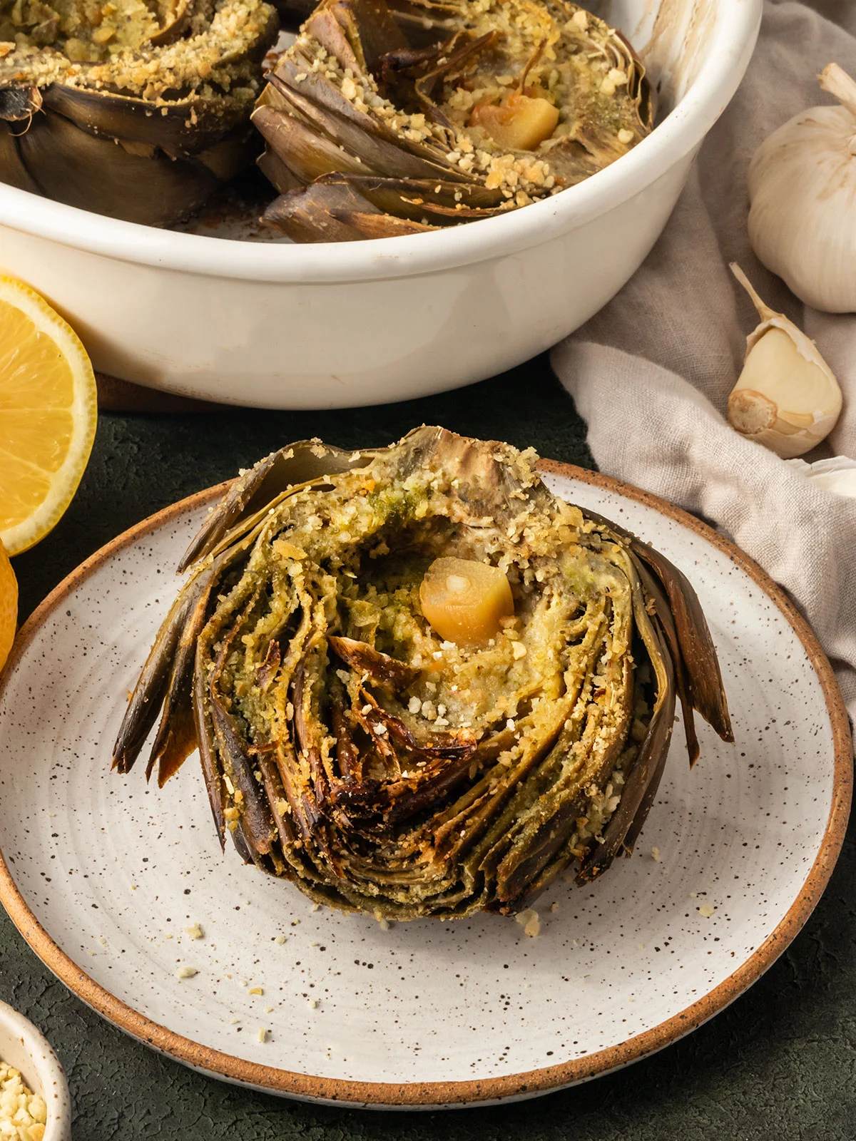 Lemon garlic roasted artichoke on a plate. 