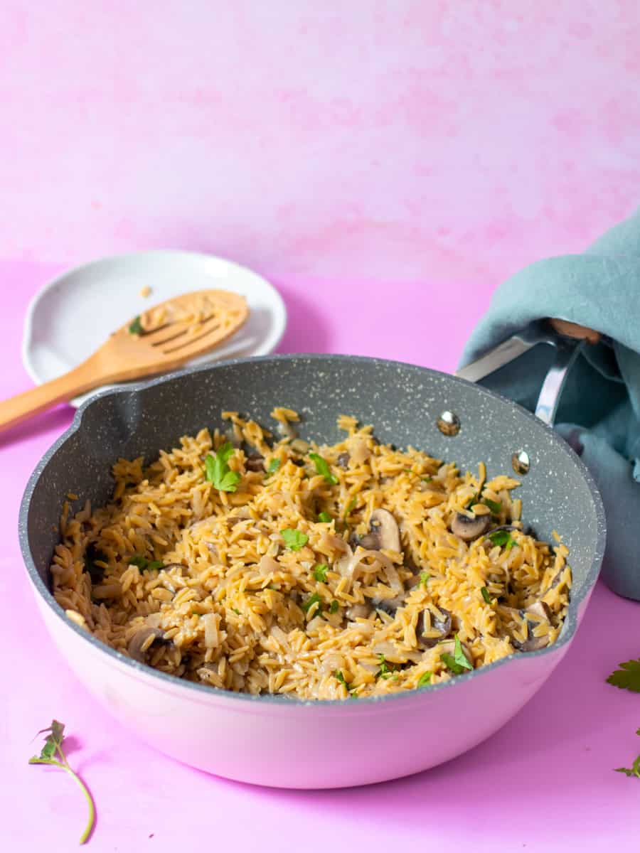 Gluten free orzo with mushrooms and onions served in a big serving bowl. 