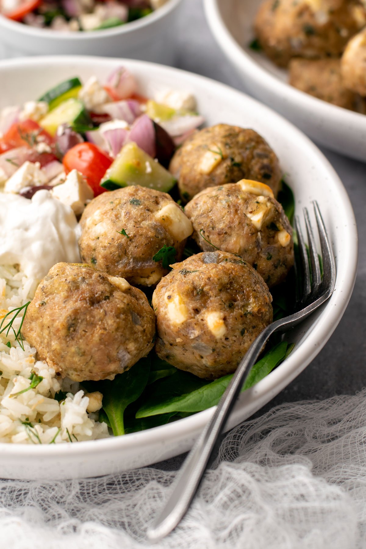 Greek chicken meatballs in a bowl served with rice. 