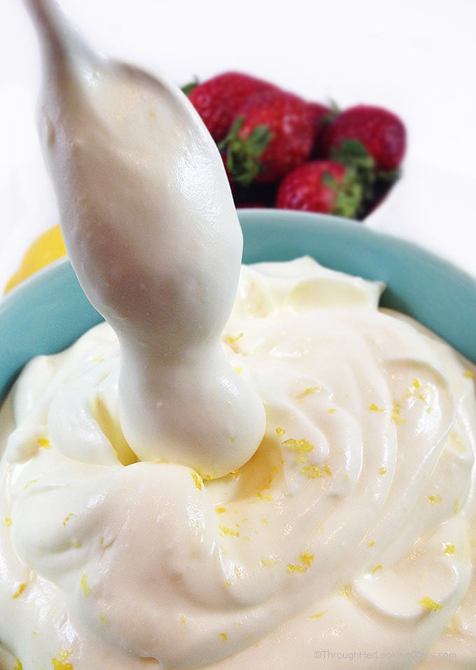 Spoon coming out of lemon cream with lemon curd. 
