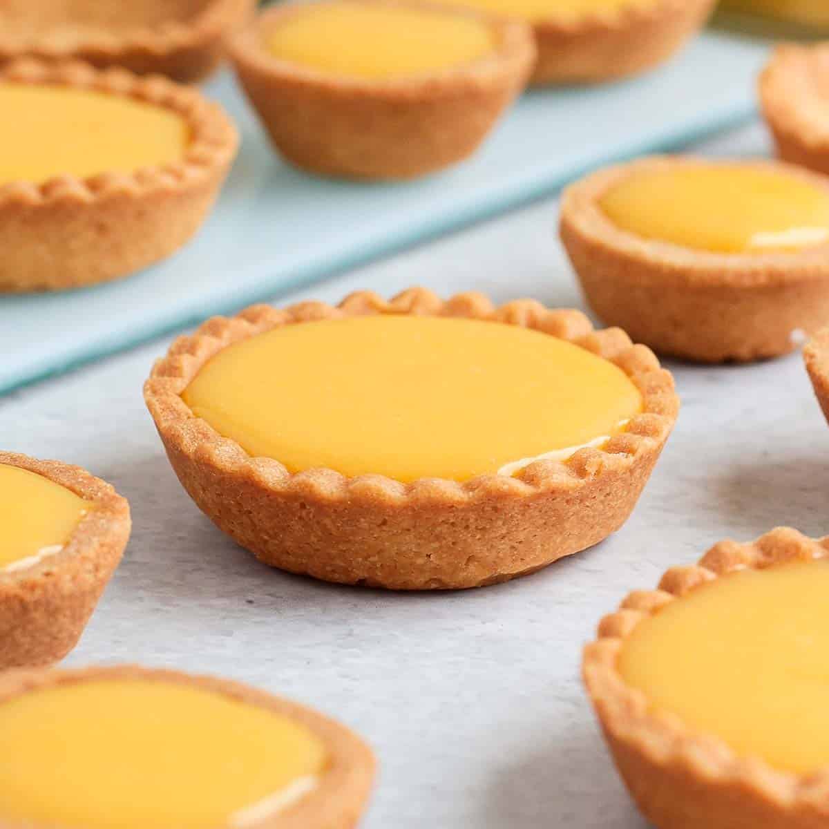 Lemon curd tartlets on parchment paper. 