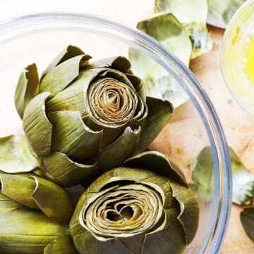 Close-up of fresh artichokes with leaves and heart visible.