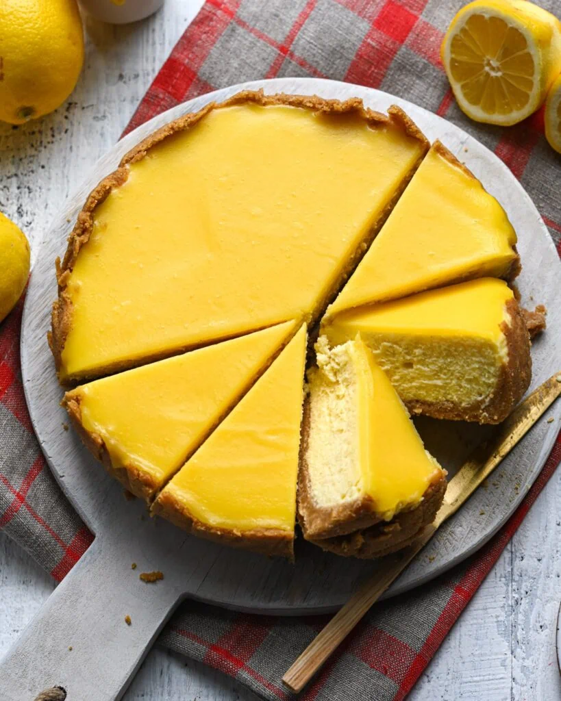 Lemon curd cheesecake sliced up and a piece turned on its side to see the inside. 