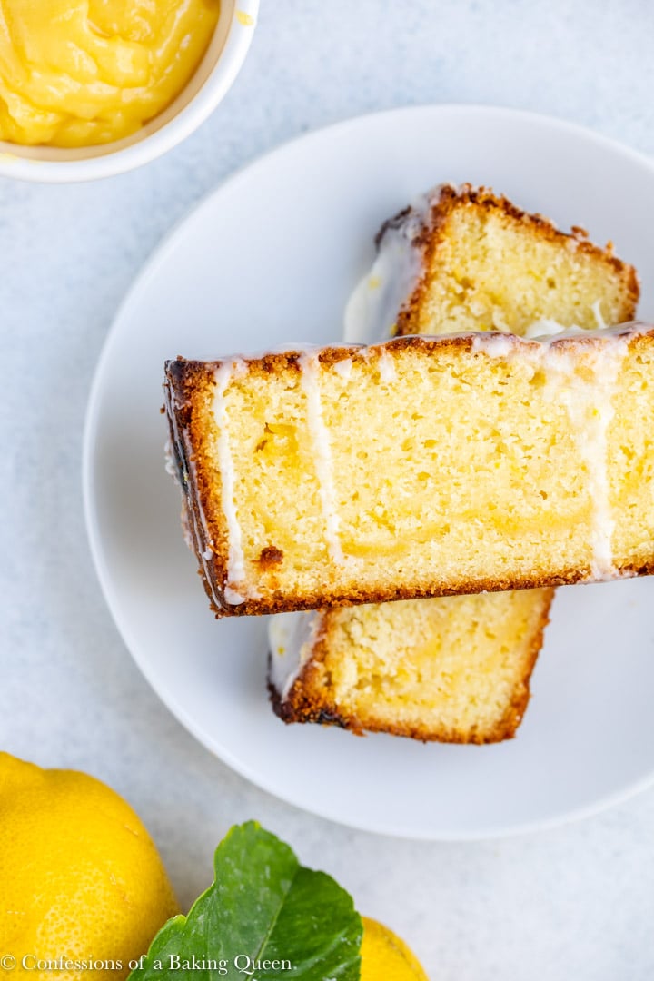 Two slices of lemon curd loaf cake on top of one another with a glaze over them. 