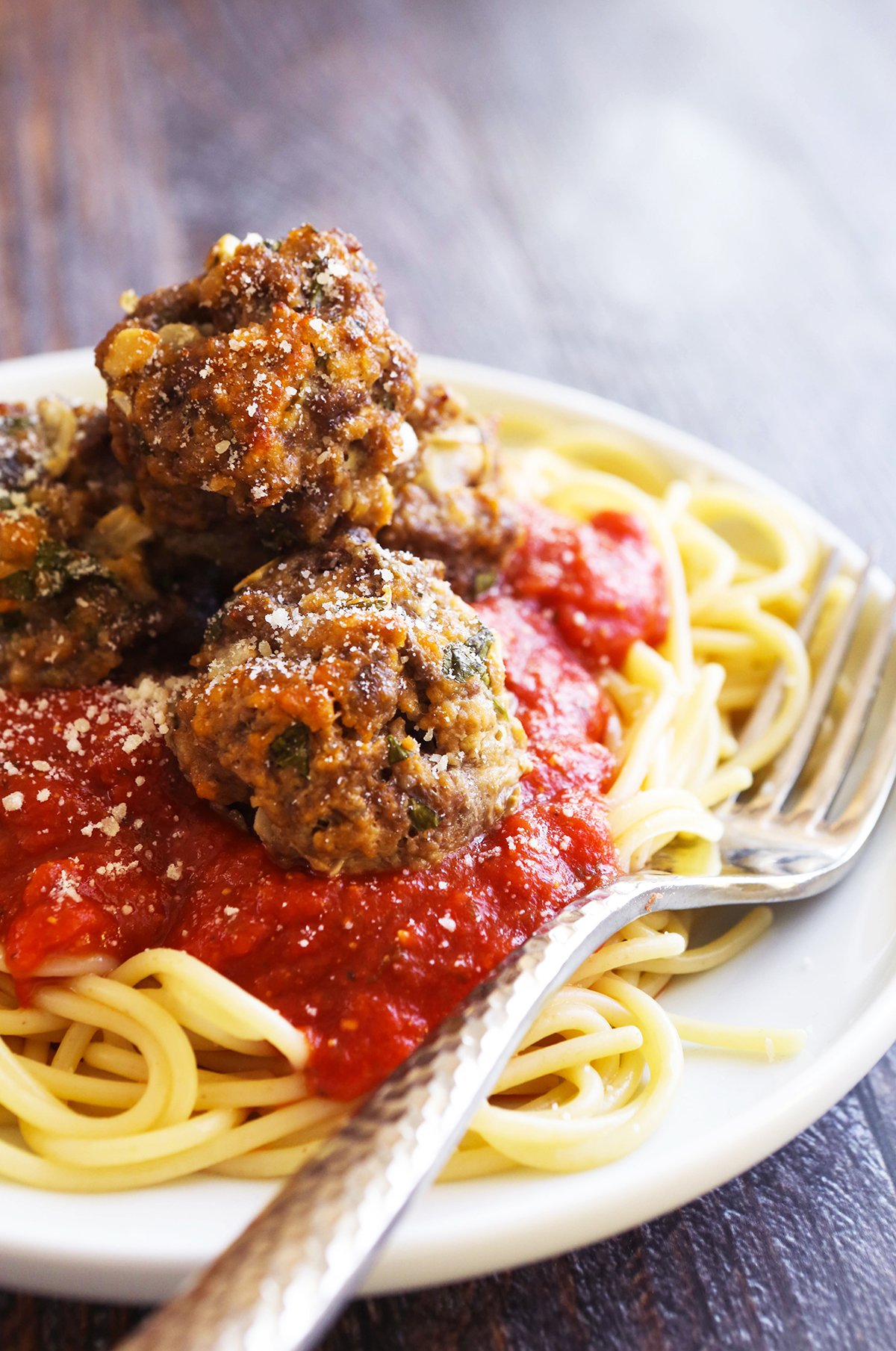 Heaping plate of spaghetti with sauce and meatballs.