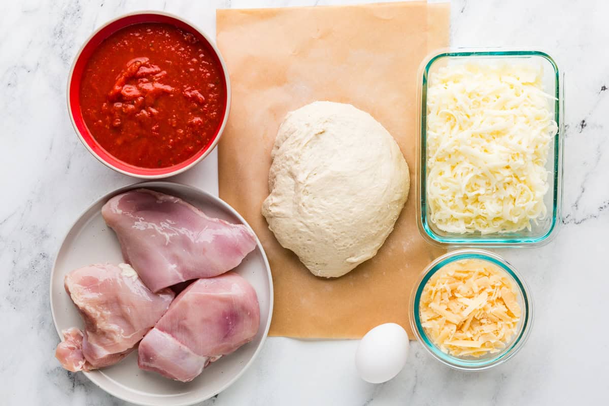 Chicken stromboli ingredients on a white counter.