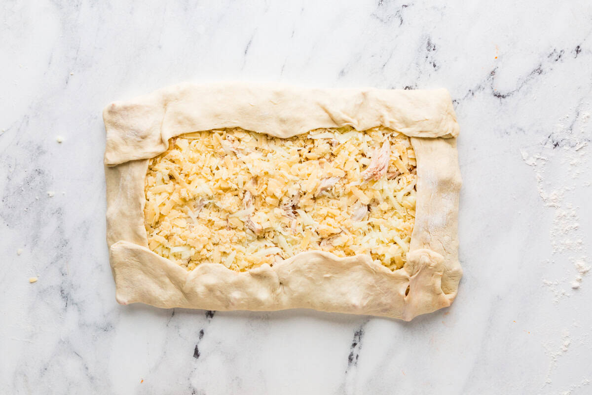 Pizza dough pinched over top of the stromboli fillings.