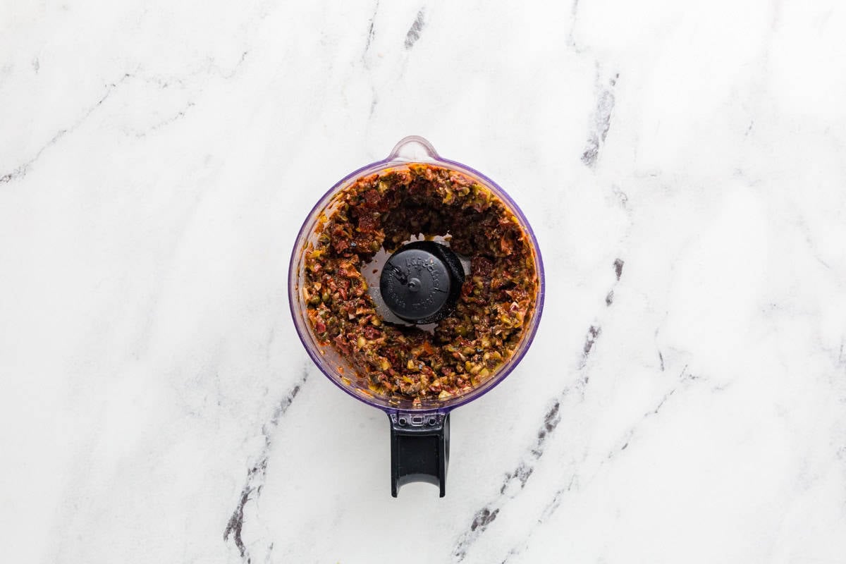 Tapenade after pulsing, in the bowl of a food processor.