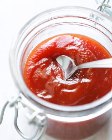 Close-up of a jar of homemade Arbys-style sauce with a spoon inside.