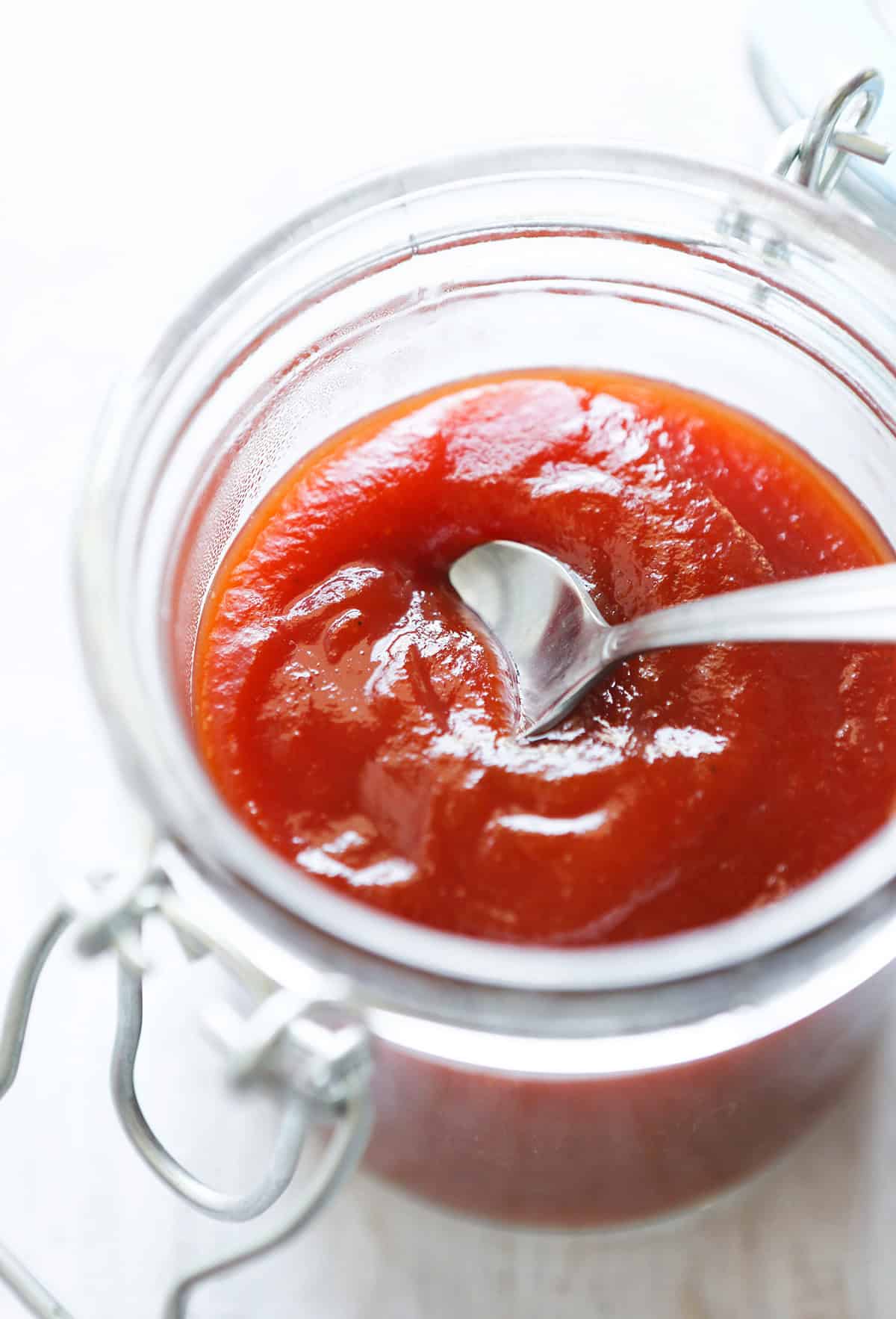 Close-up of a jar of homemade Arbys-style sauce with a spoon inside.
