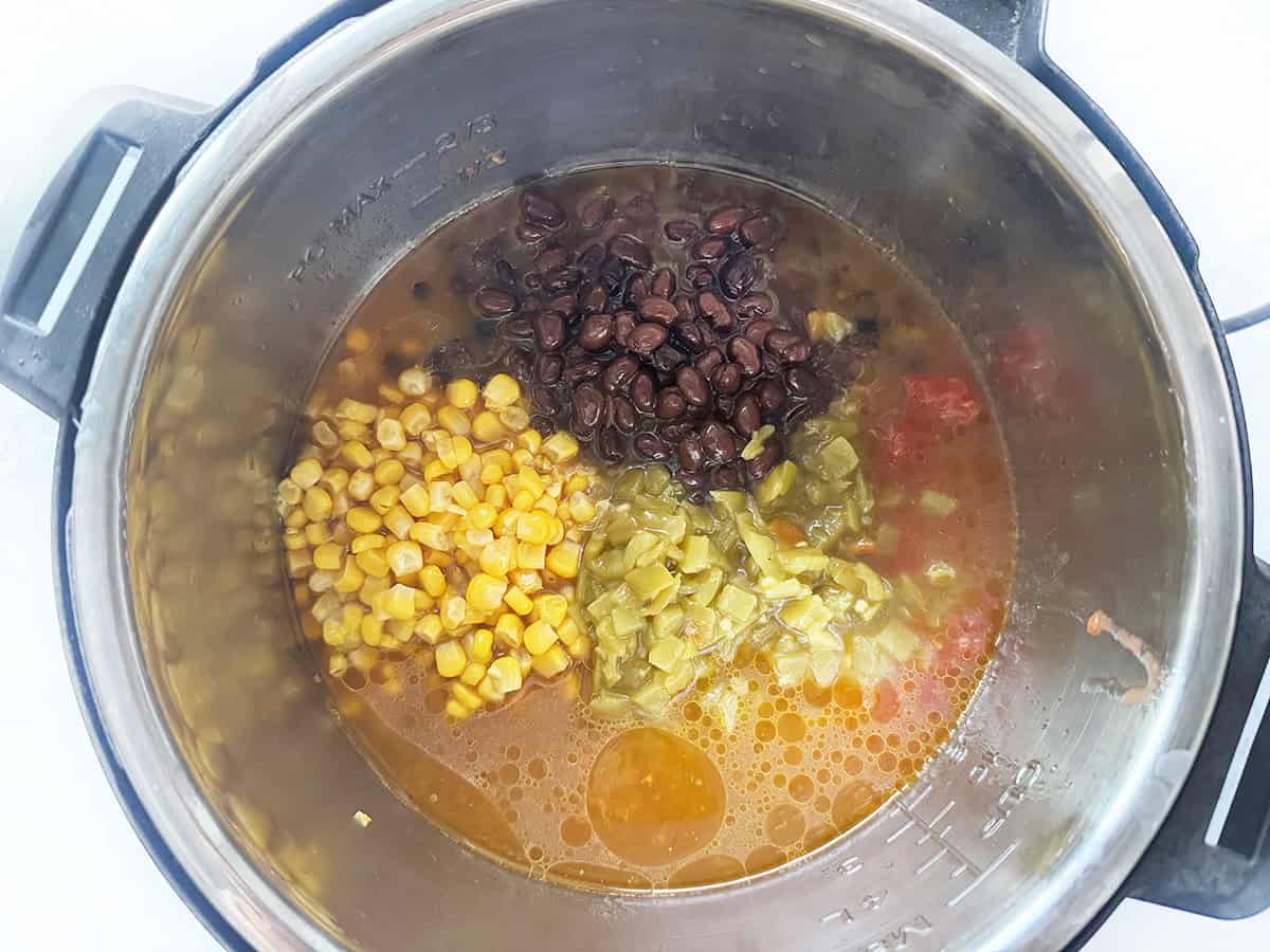 Healthy corn and black bean soup with vegetables in a slow cooker.