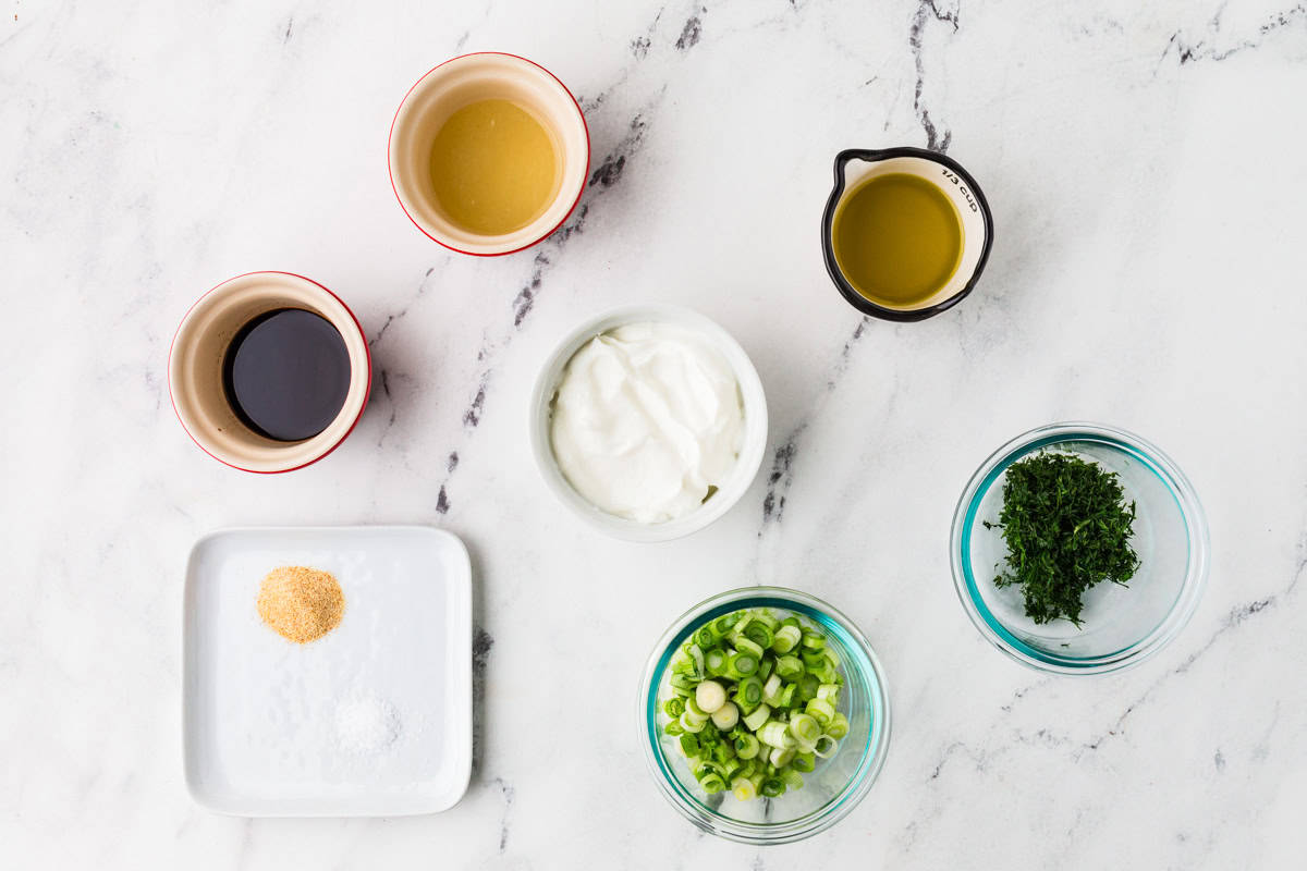 Ingredients for yogurt dill dip lined up on a white counter.