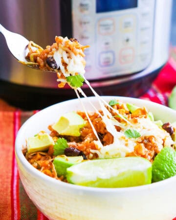 Delicious burrito bowl with avocado, black beans, and cilantro in a white bowl.