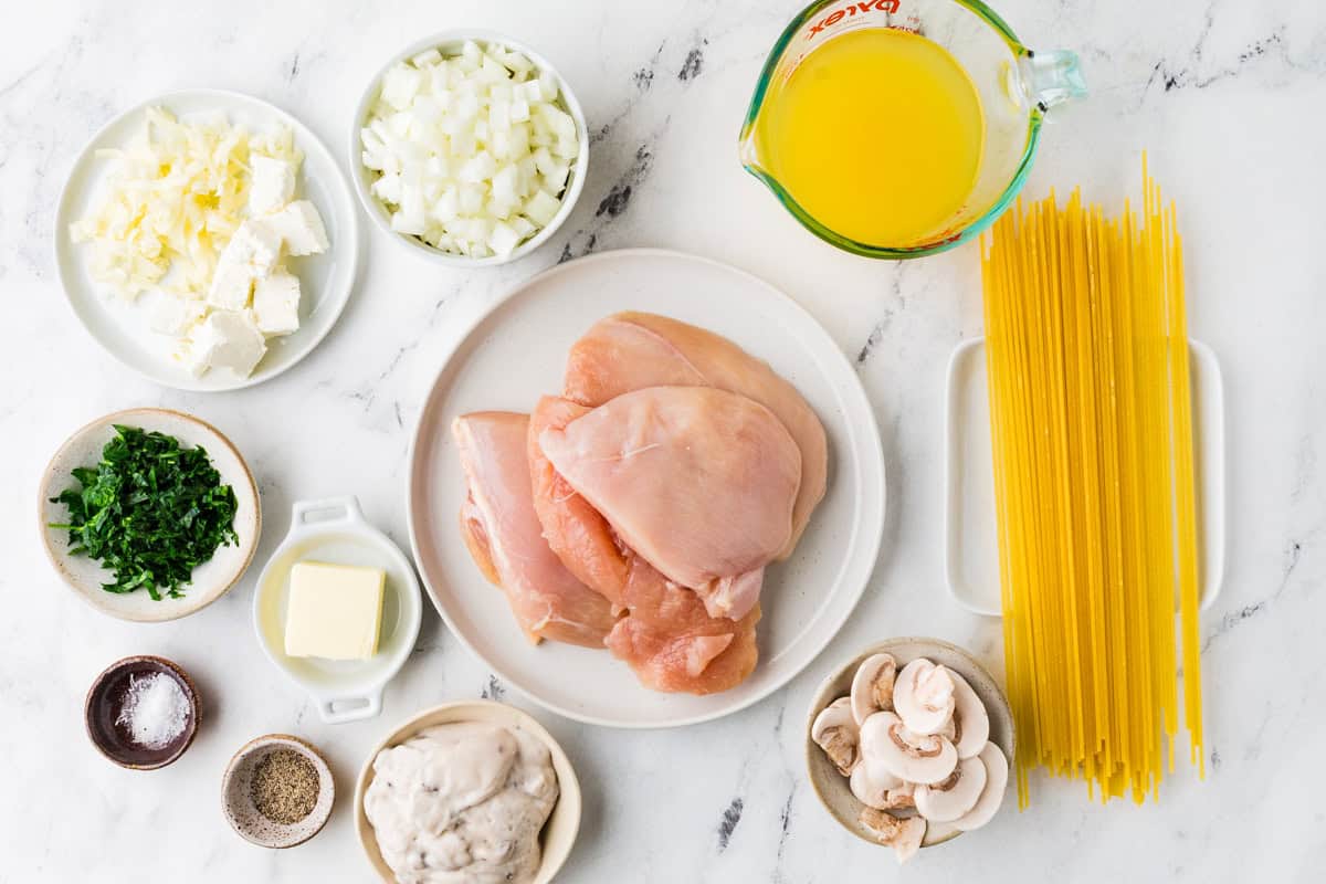 Ingredients for slow cooker chicken tetrazzini on a white counter top.
