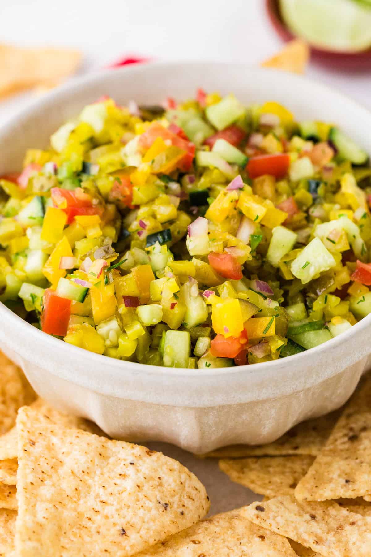 Bowl filled with pickle de gallo, surrounded by tortilla chips.