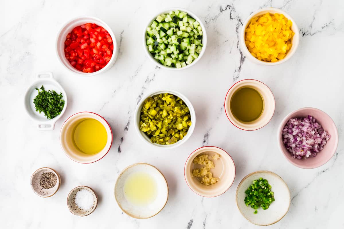 Ingredients for fresh salsa lined up on a white counter.