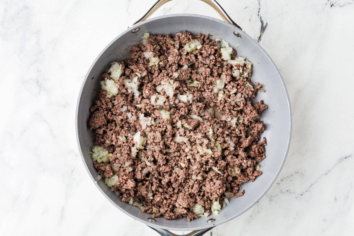 Ground beef onion mixture in a skillet.