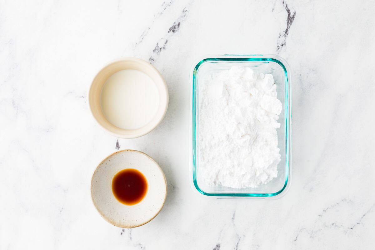 Ingredients for icing glaze on a white counter.