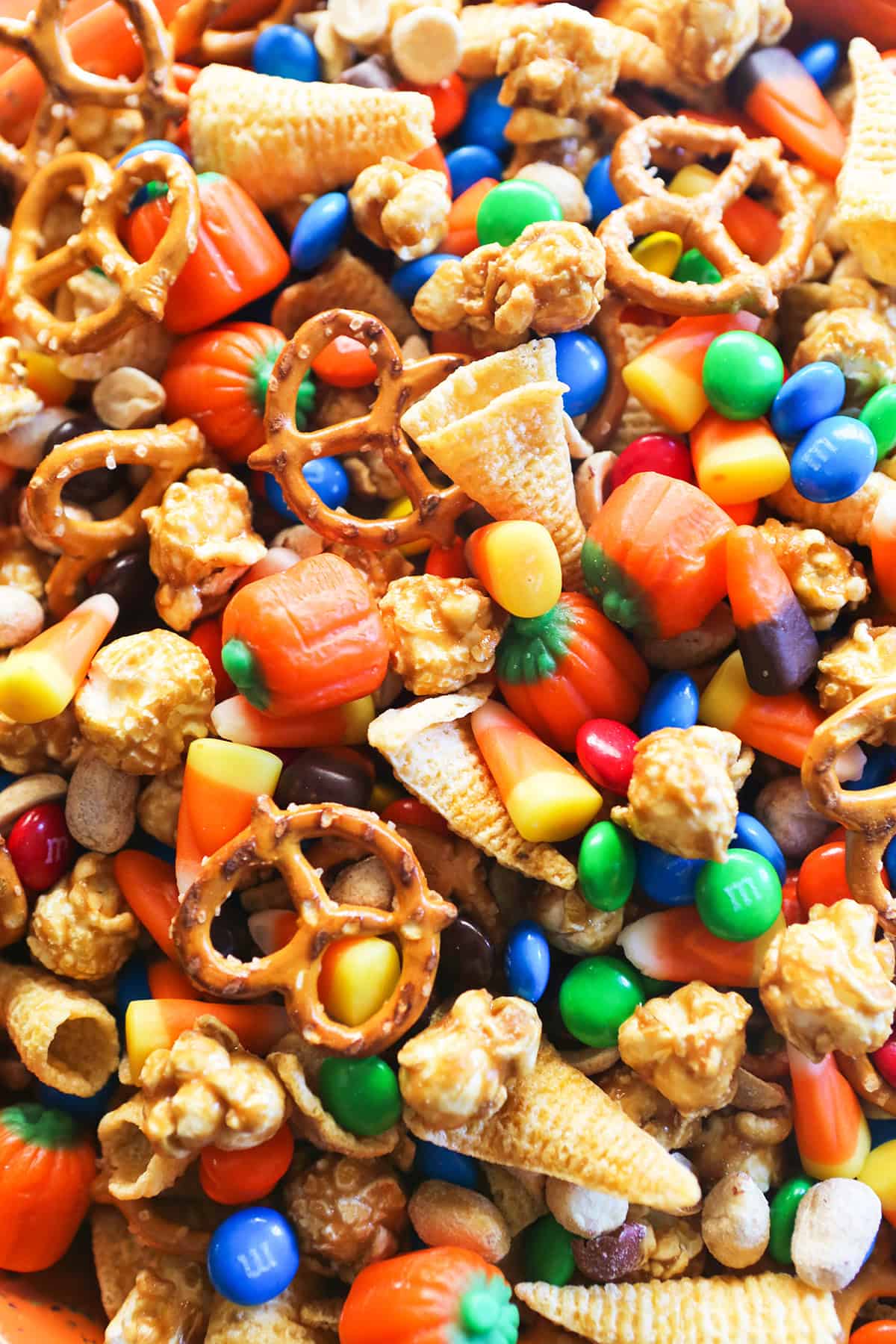 Colorful Halloween snack mix with candy, pretzels, and popcorn for festive treats.