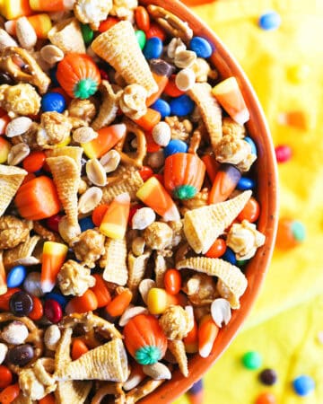 Colorful Halloween snack mix with candy corn, M&Ms, and popcorn in a bowl.