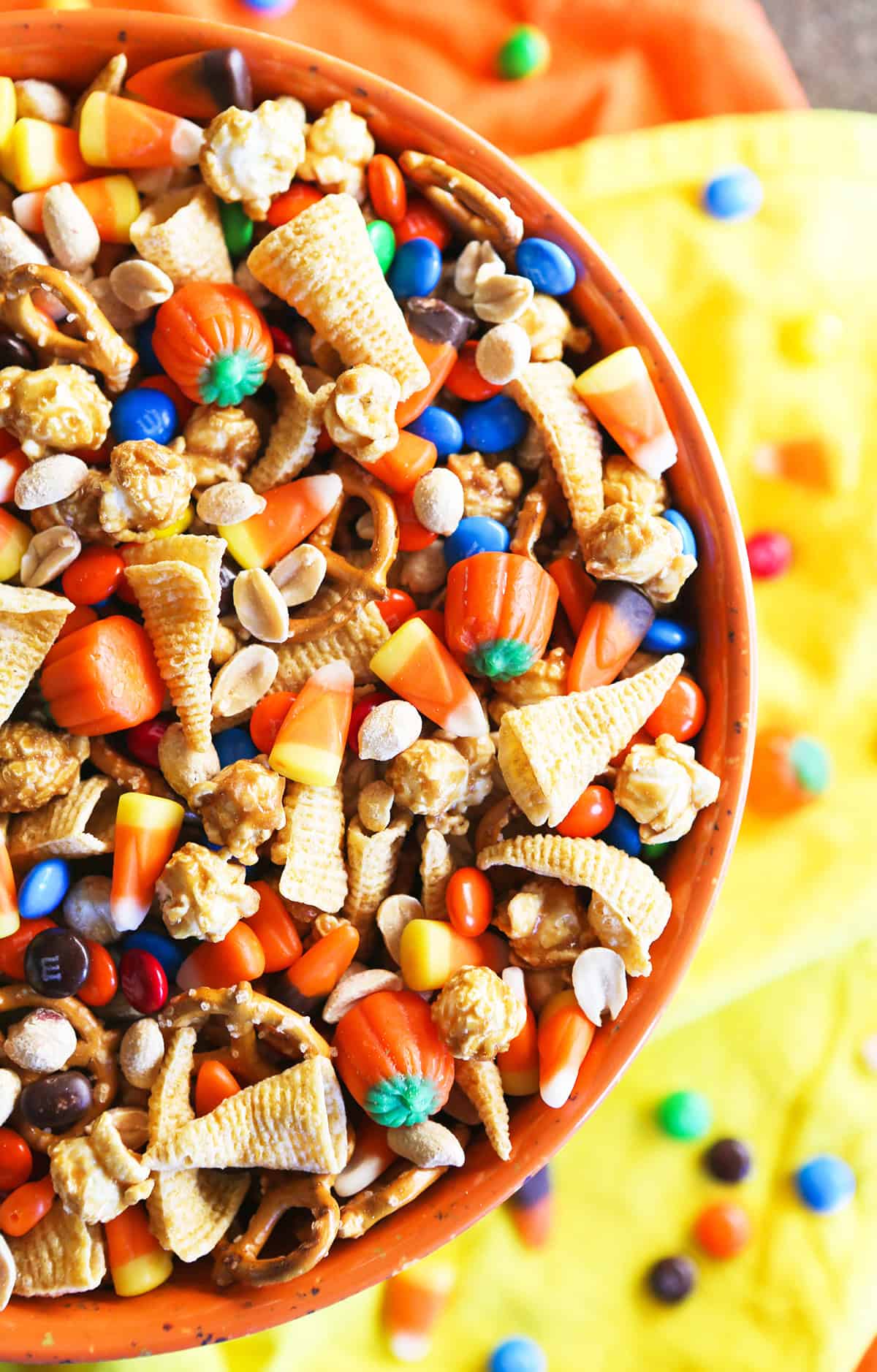 Colorful Halloween snack mix with candy corn, M&Ms, and popcorn in a bowl.