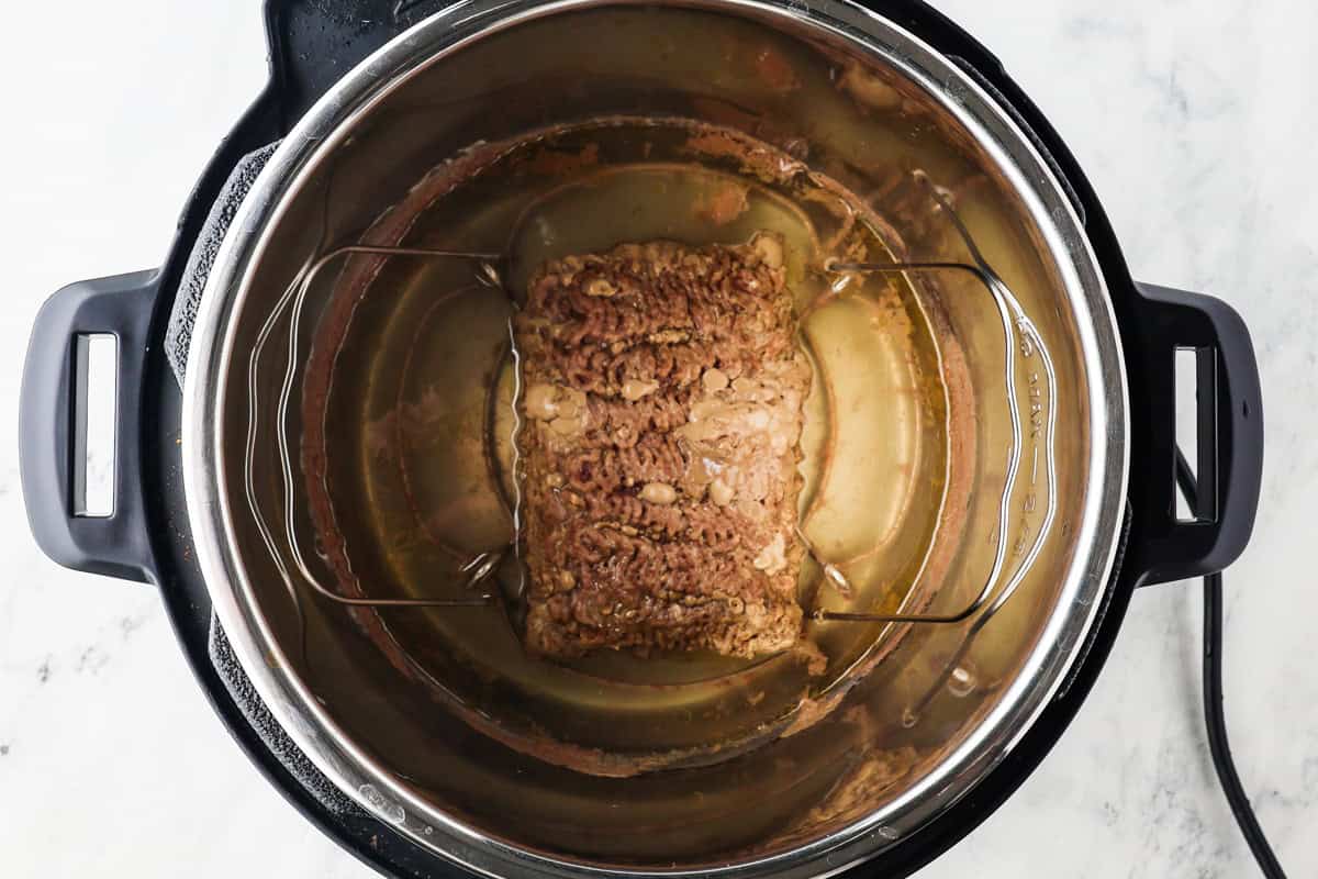 Pound of cooked ground beef on a trivet inside an Instant Pot.