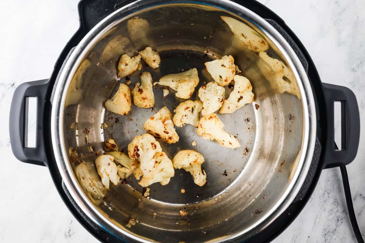 Instant Pot with browned cauliflower florets inside.