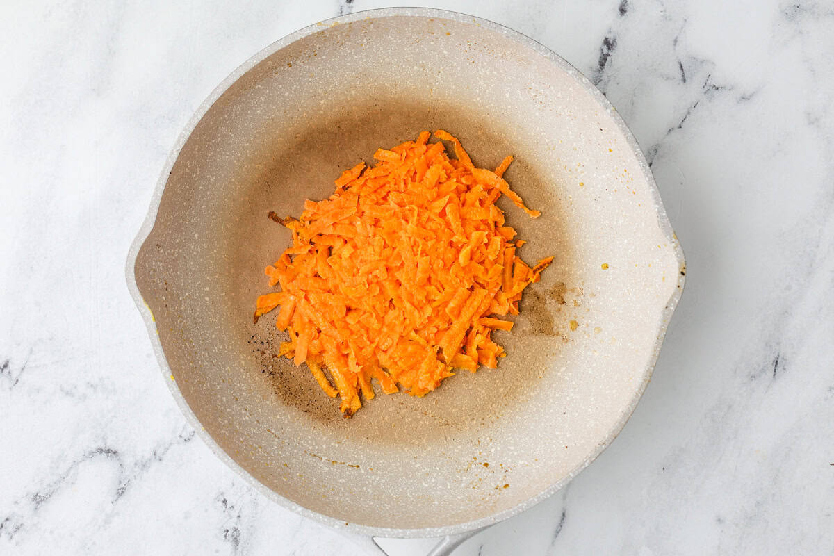 Shredded sweet potatoes in a skillet.