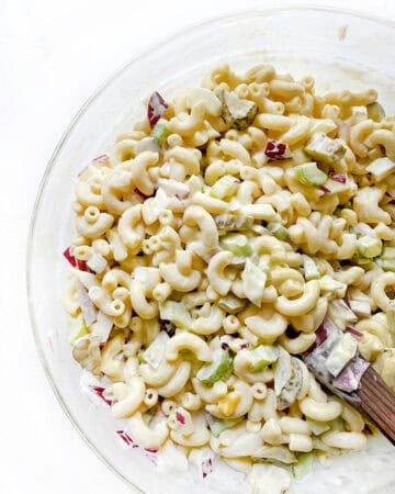 Creamy macaroni salad with chopped vegetables, perfect for picnics and summer meals.