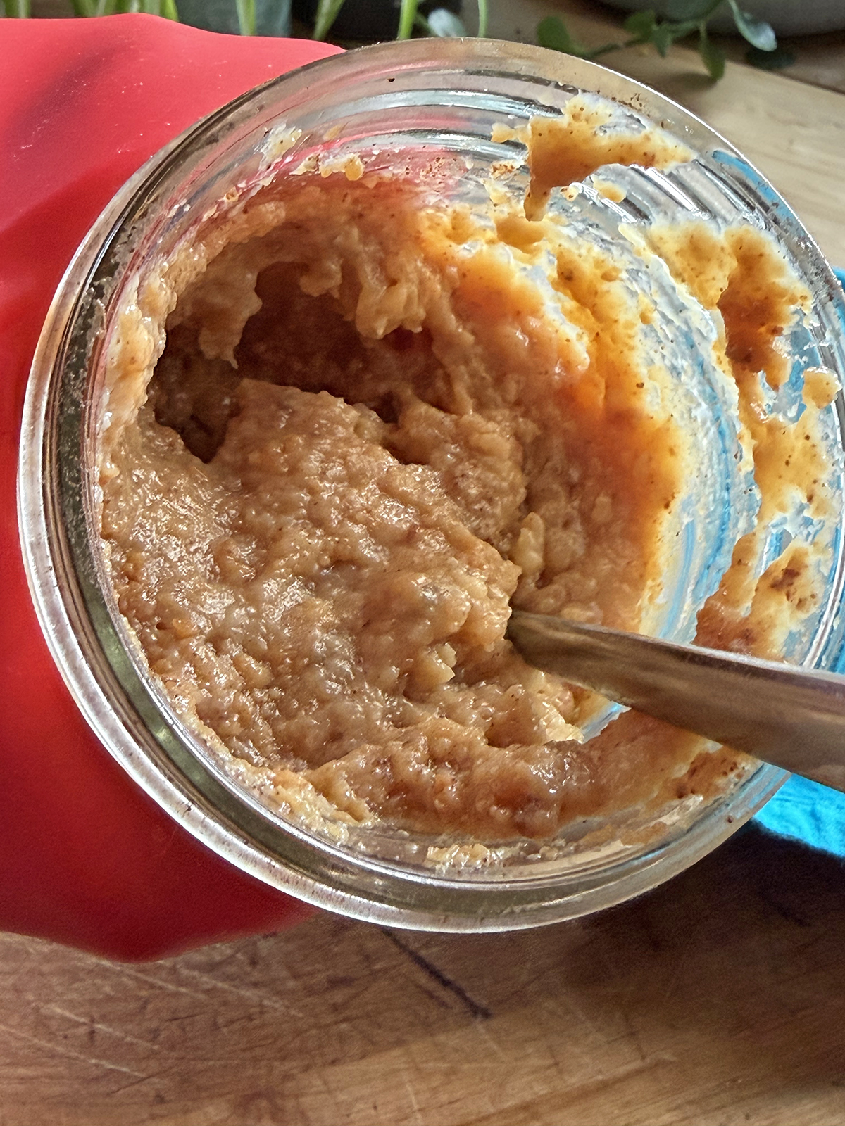 Homemade sweet potato baby food puree in a glass jar with a spoon.
