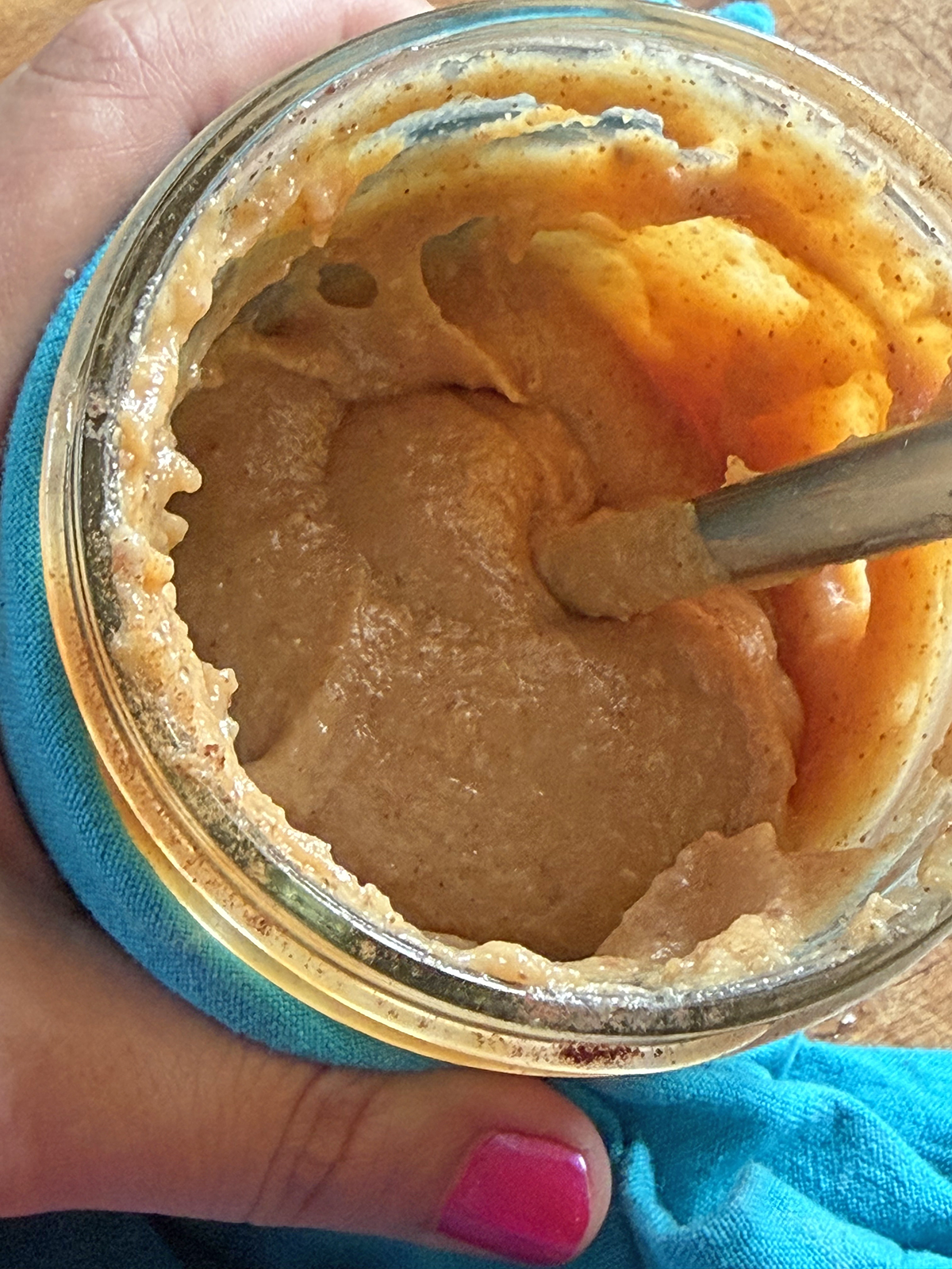 Baby food puree jar with spoon, showing smooth, nutritious baby food.