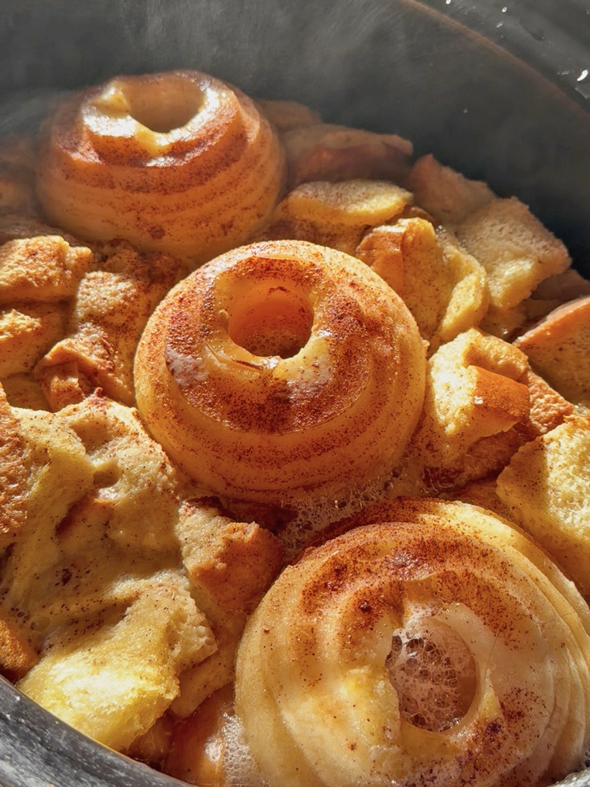 Baked French toast with apple slices and cinnamon in a baking dish.