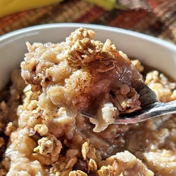 Creamy banana oatmeal topped with crushed graham crackers in a bowl.