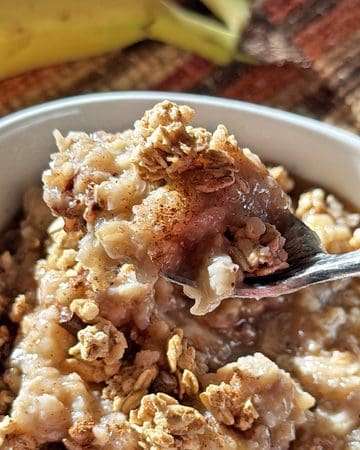 Creamy banana oatmeal topped with crushed graham crackers in a bowl.