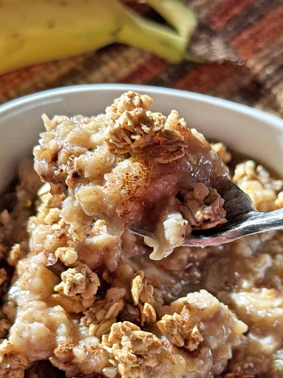 Creamy banana oatmeal topped with crushed graham crackers in a bowl.