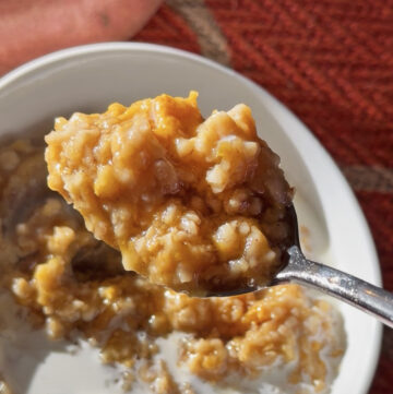Creamy sweet potato oatmeal with oats and melted butter on a spoon.
