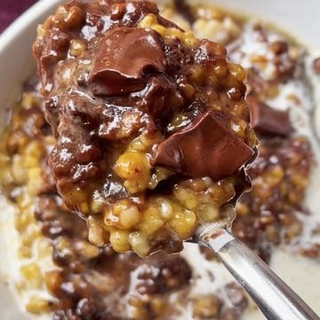 Creamy oats with melted chocolate chunks and corn kernels in a bowl.