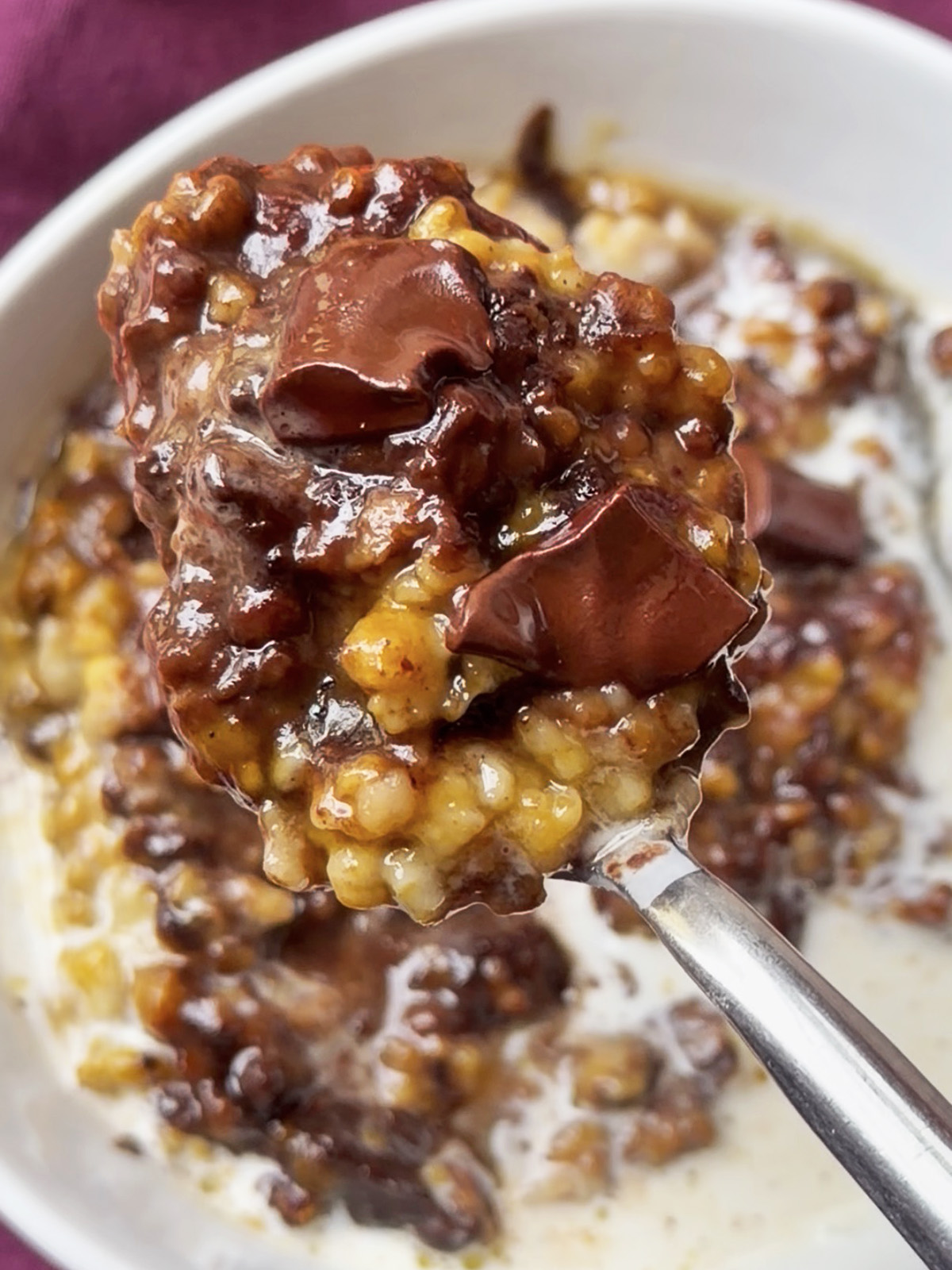 Creamy oats with melted chocolate chunks and corn kernels in a bowl.